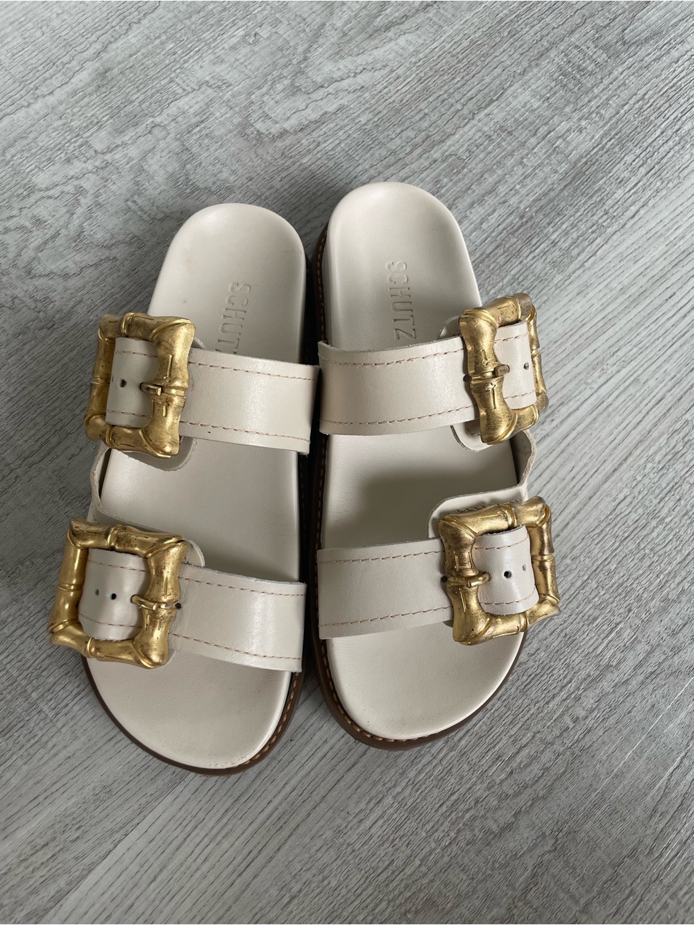 SCHUTZ Cream Slide Sandals with Gold Buckle Accents